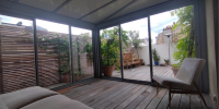 Belle véranda sur une terrasse en toiture à Paris 15e, fabriquée dans notre atelier à Draveil