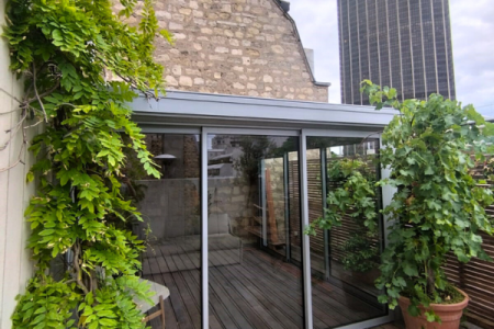 Belle véranda sur une terrasse en toiture à Paris 15e, fabriquée dans notre atelier à Draveil